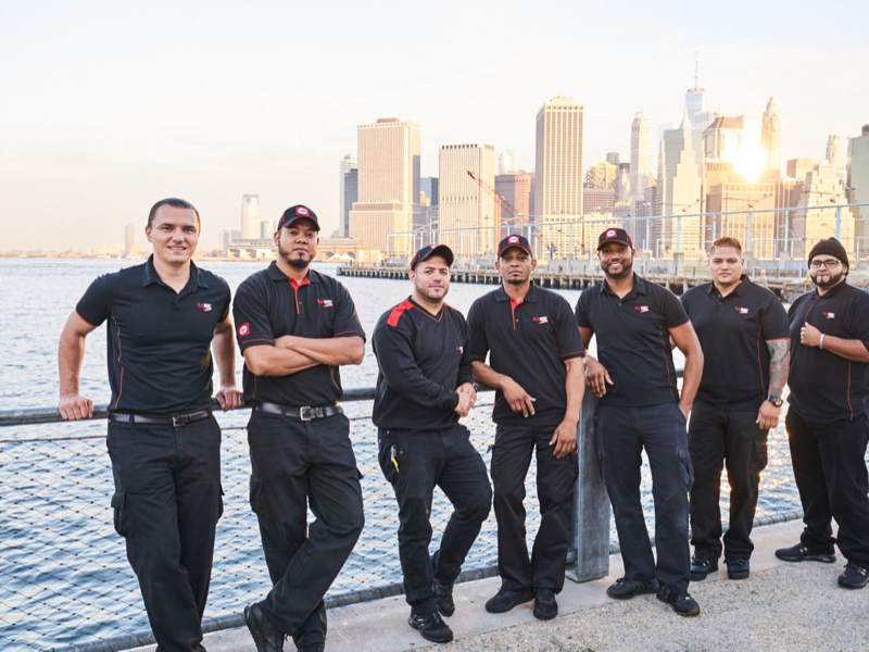 FlatRate moving team poses in front of NYC skyline