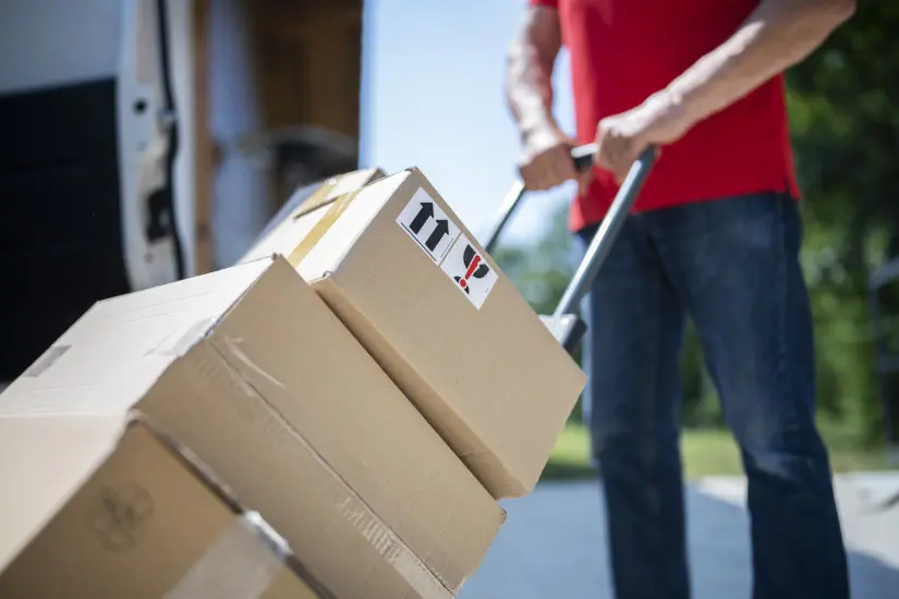 Man with red T shirt moving a couple of boxes